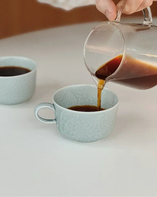 V60 filter coffee poured from a glass server into a cup